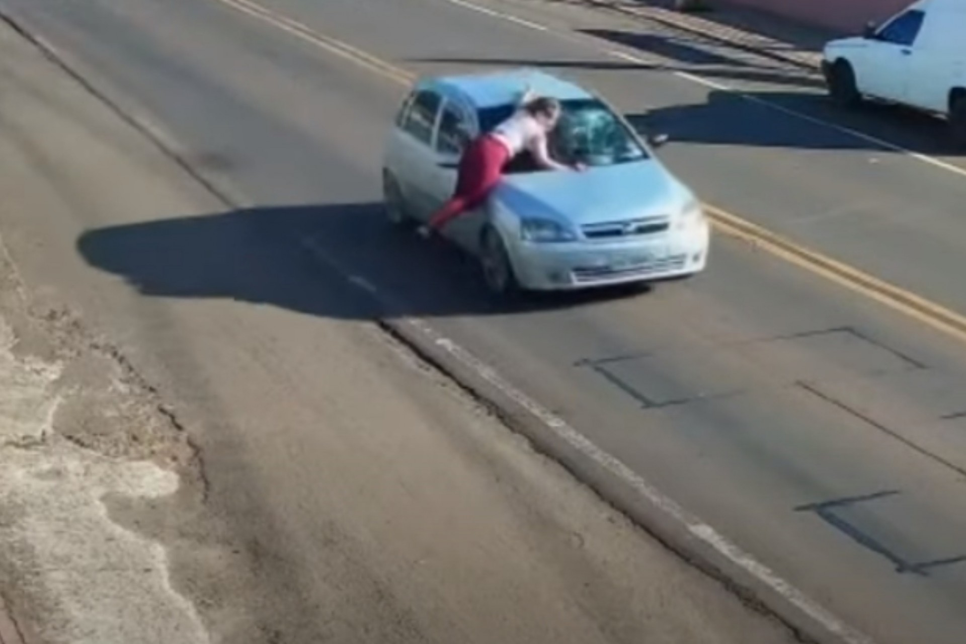 Câmeras flagram mulher sendo transportada em capô de veículo no Paraná