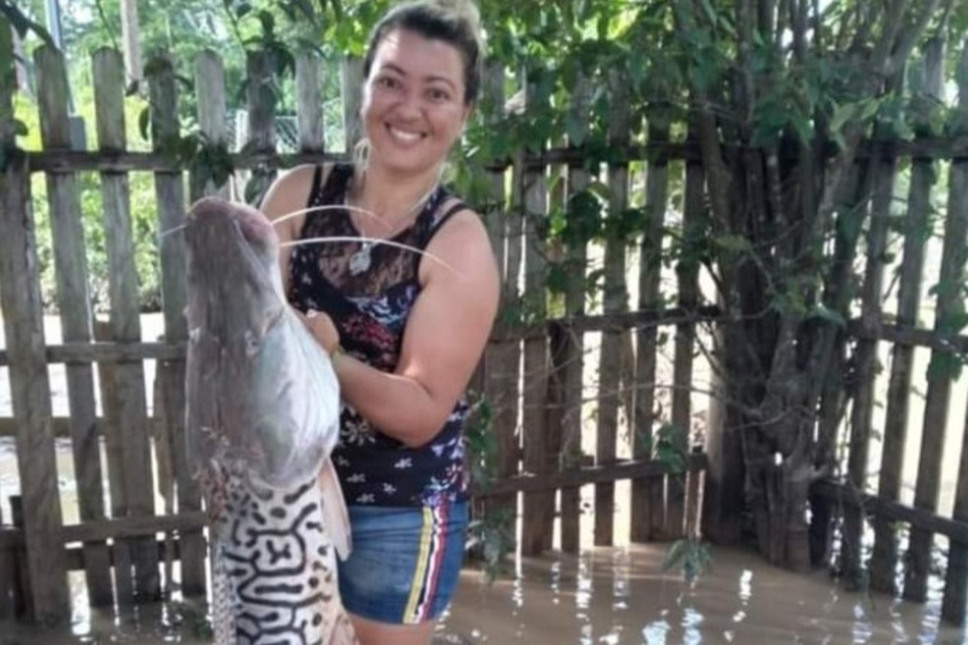 Mulher acha peixe de 12 quilos e 1,10 metro no quintal de casa atingida por cheia