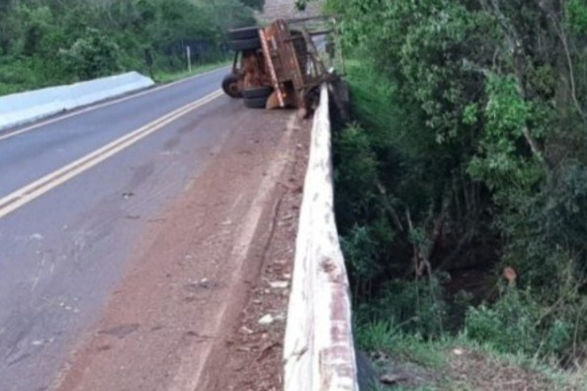 Paraná: Caminhão com tora de madeira tomba e passageiro fica ferido na PR 180
